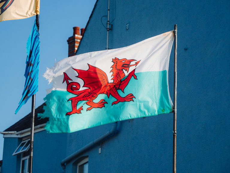 Baner Cymru yn erbyn cefndir awyr.