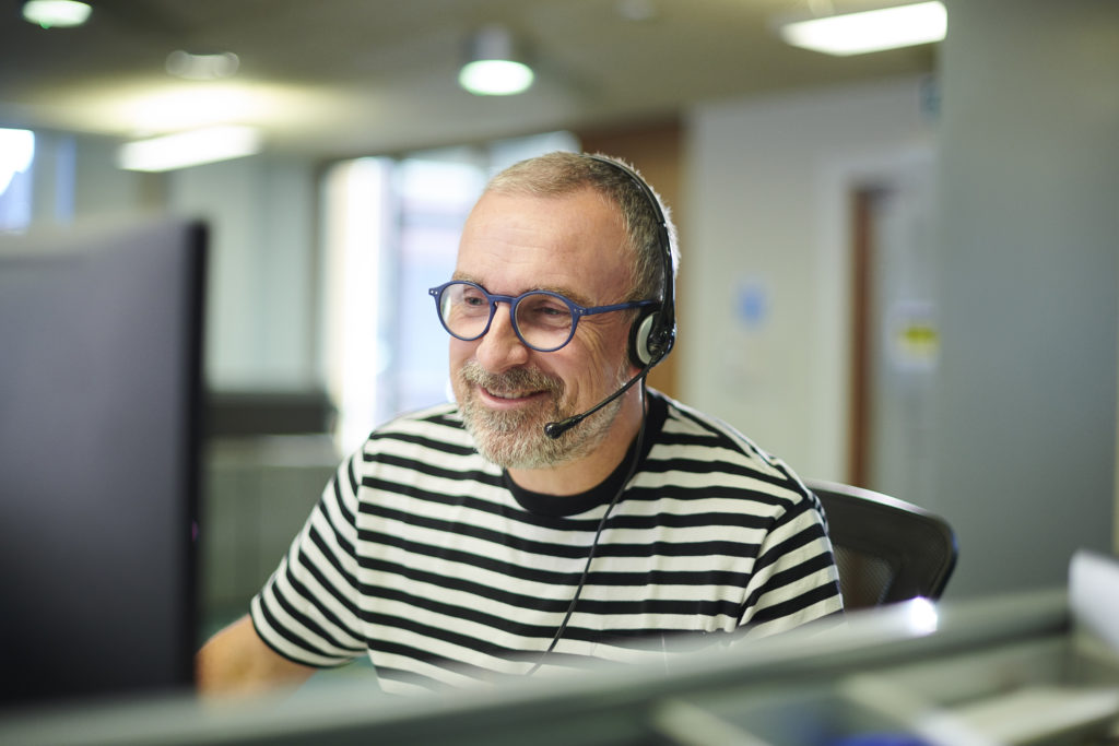 man on a computer wearing a headset