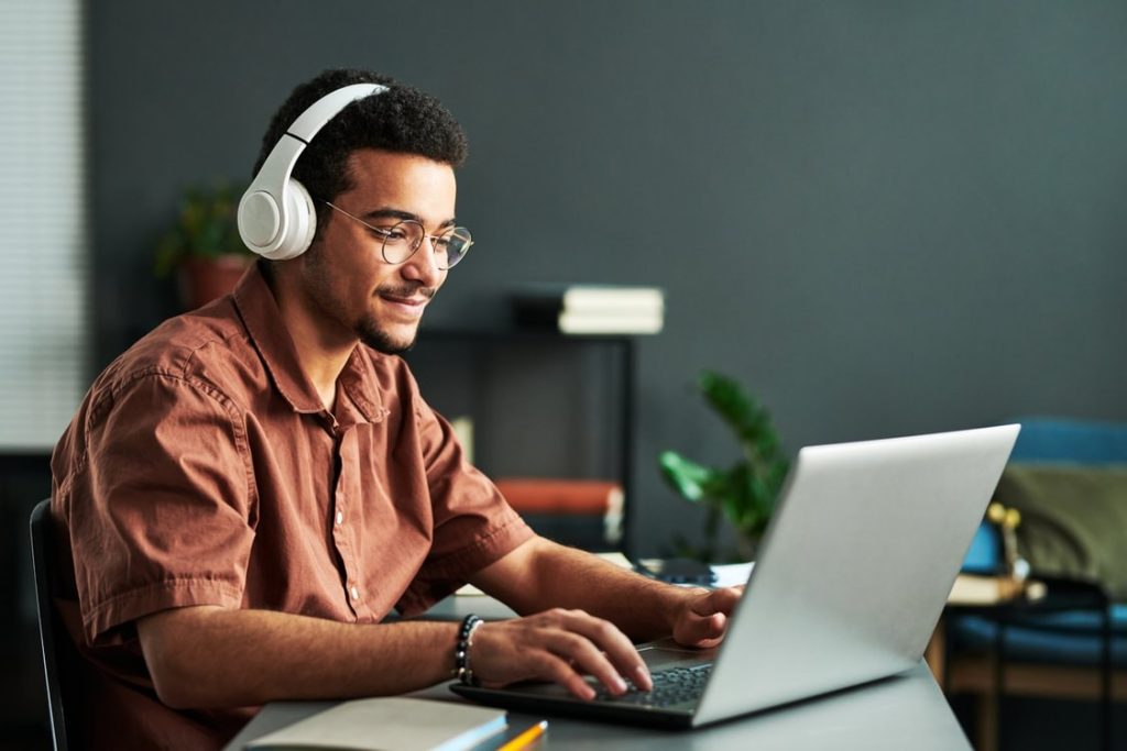 A man with headphones at a laptop.