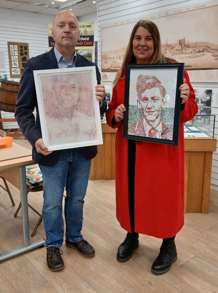 A man and a woman holding portraits of Terry Higgins.
