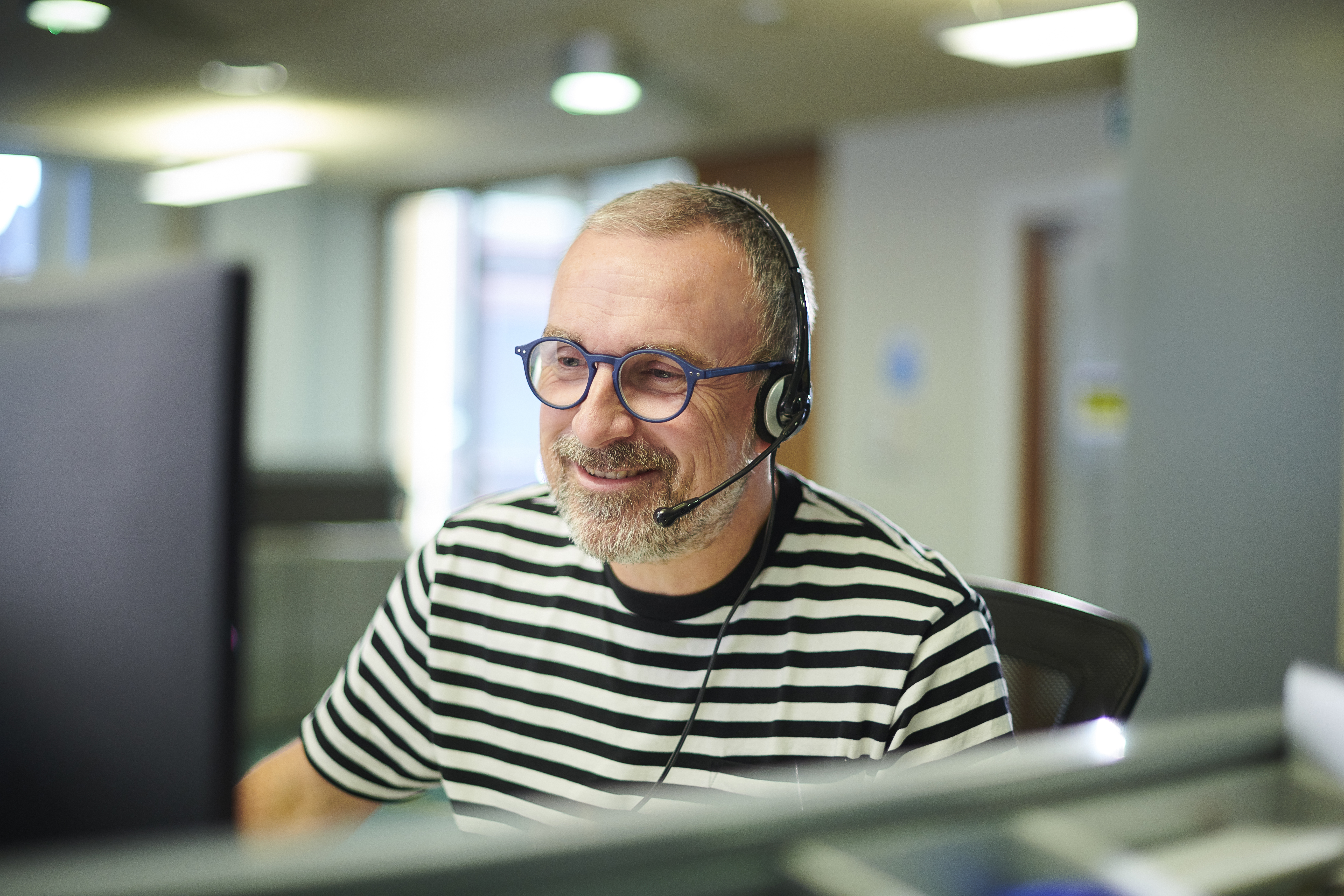 man with headset at a computer