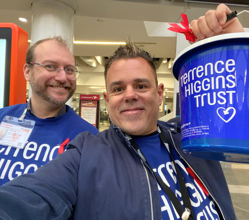 two men holding bucket collections for Terrence Higgins Trust