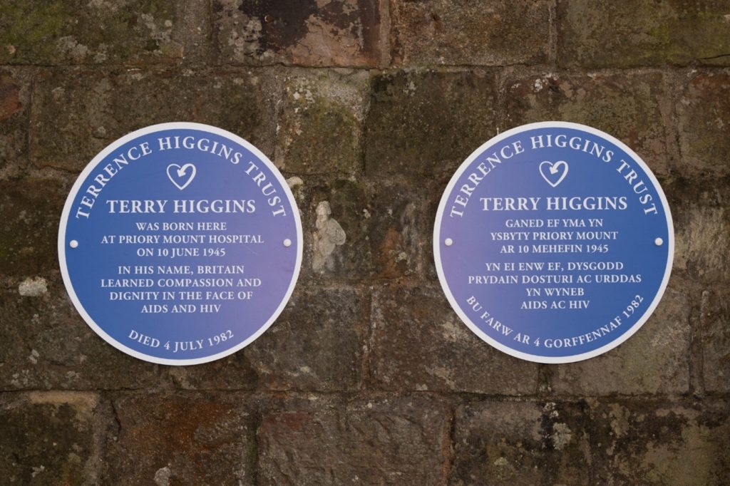 Two blue plaques, one in English and one in Welsh.